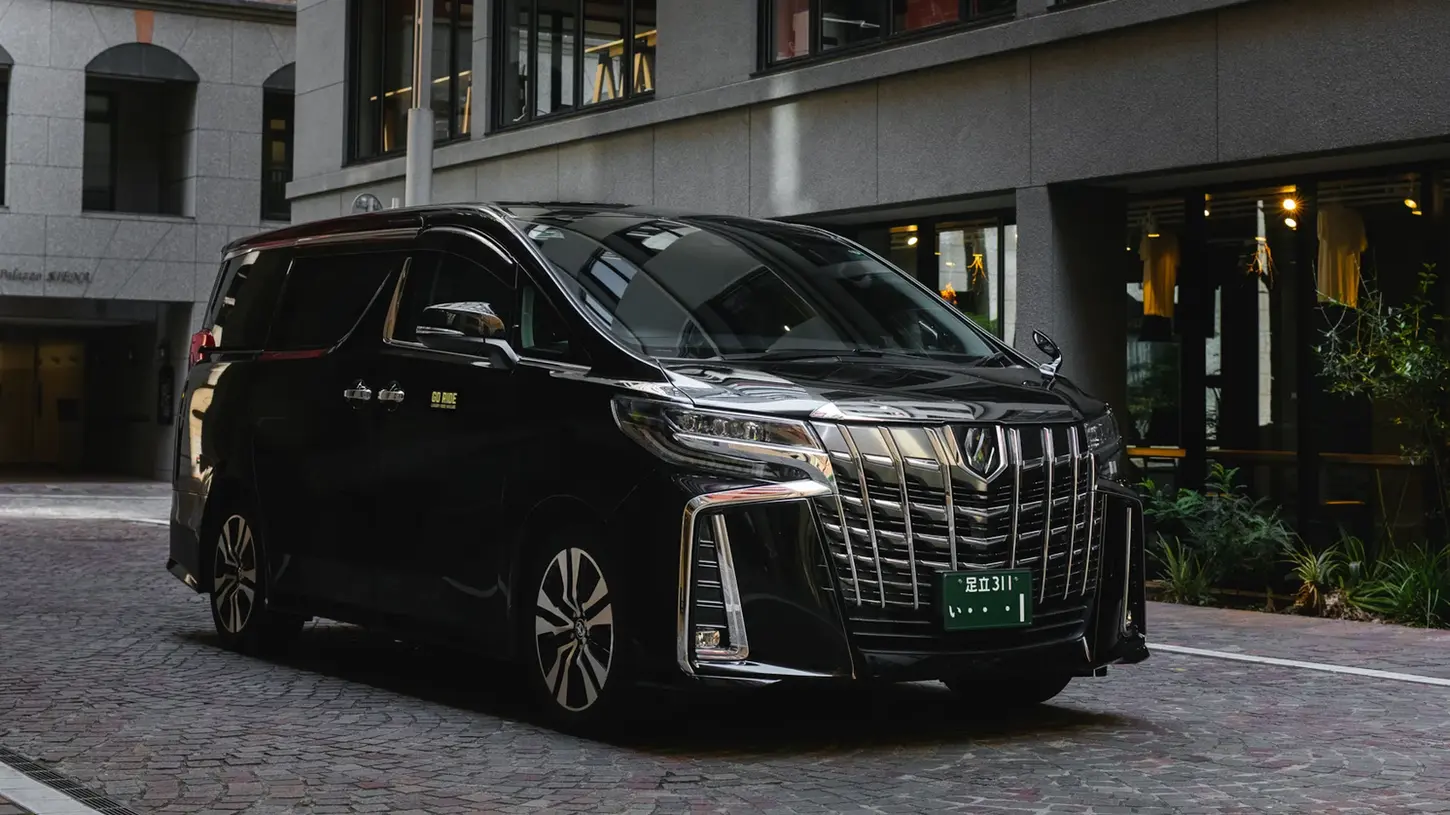 Black Toyota Alphard 30 Series front angle green plate fancy city background