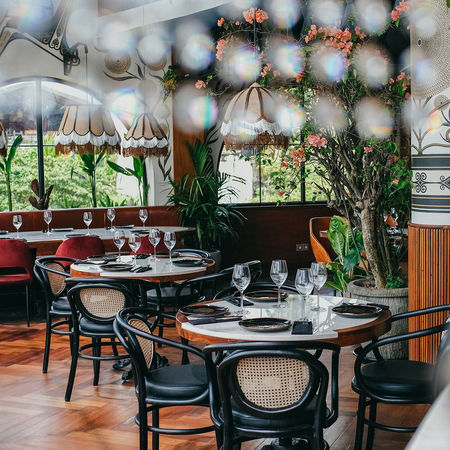 restaurant room, santanera in canggu, bali. round table with teak frame and marble top, Balinese teak chair with rattan back