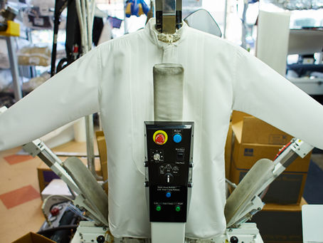 Shirt on a professional pressing machine at a dry cleaning facility, showing advanced garment care equipment.
