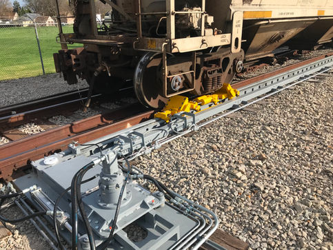 Railcar wheel, yellow chocks, railcar mover, and gate opener.