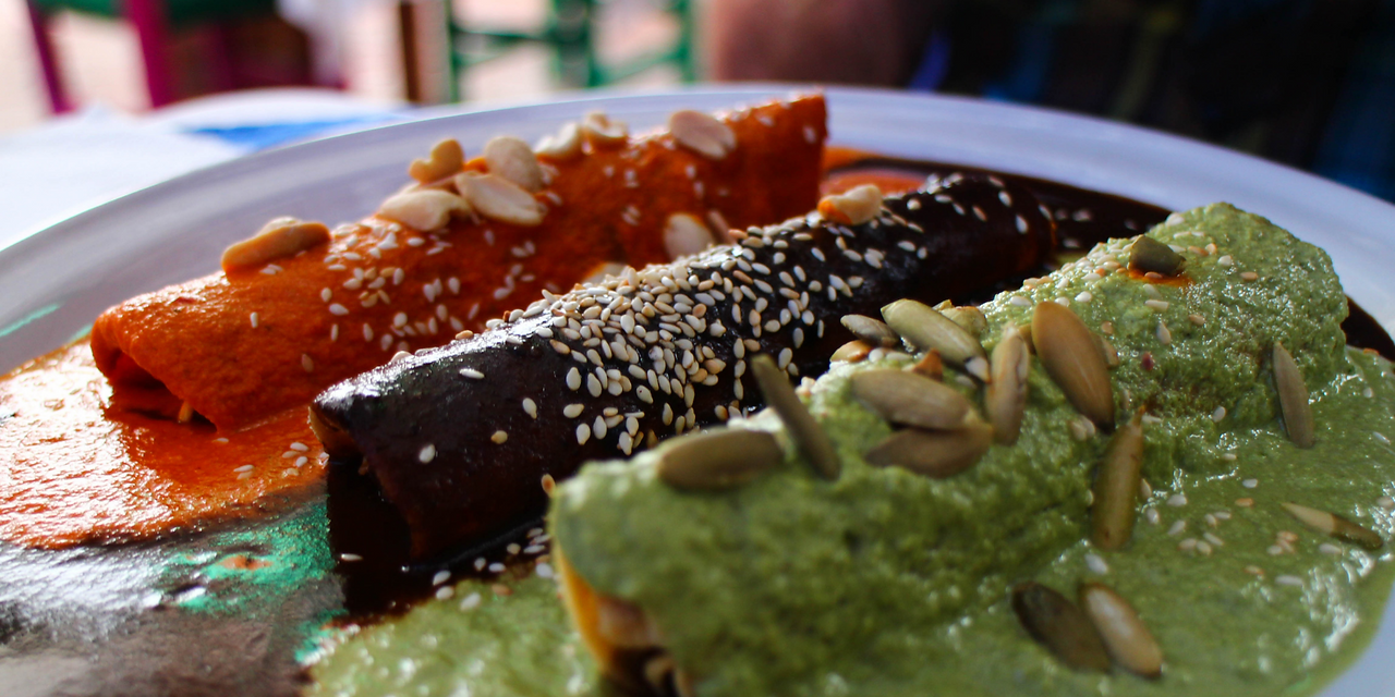 Enmolados (rolled tortillas) dippled in three types and colors of Oaxacan mole (red, black, green)