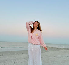 Mady Vivian standing in front of ocean at sunrise