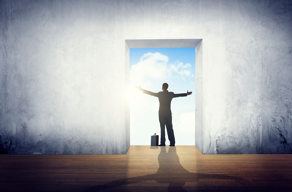 A person in a suit stands in a doorway with arms wide open, facing a sunny blue sky. A briefcase is on the ground, and the room is gray.