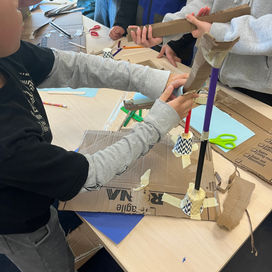Students collaboratively build a  roller coaster