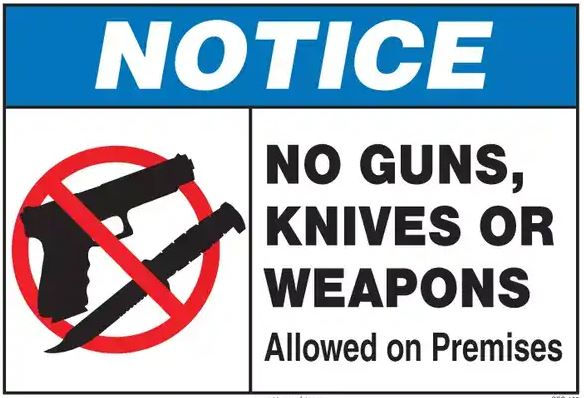 Blue and white notice sign with a crossed-out gun and knife. Text: "NO GUNS, KNIVES OR WEAPONS Allowed on Premises."