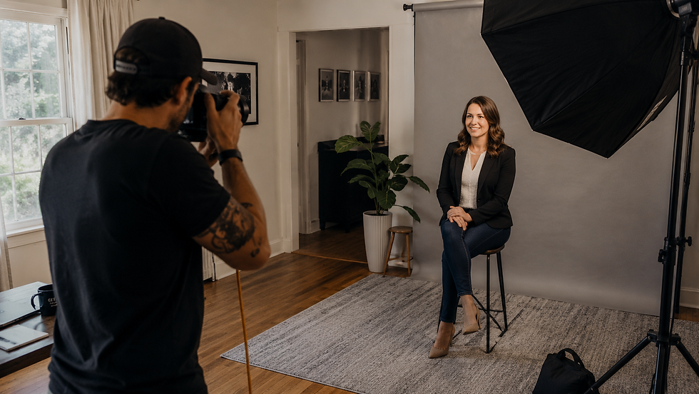 Portrait photographer working a headshot session inside a converted home studio with a softbox light and residential interior cues. Illustrates the home studio liability point for sole proprietors considering an LLC.
