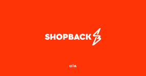 White "SHOPBACK" text with lightning bolt logo on bright orange background. Below, "COINS TO CASH DOLLARS" logo.