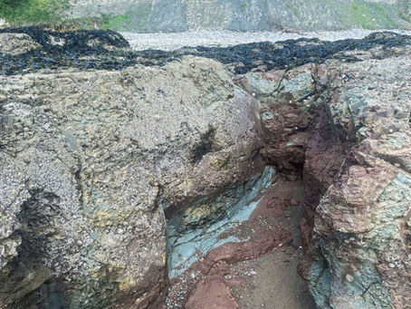 A crevice in the rocks with cliffs behind.