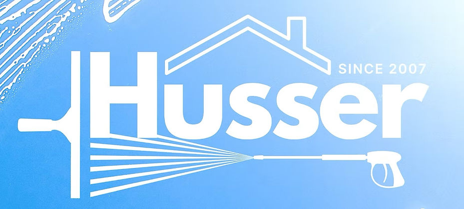 Husser logo against a blue sky with soap suds