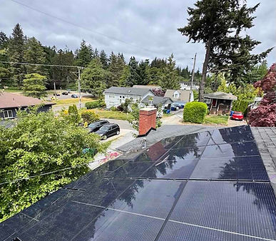 recently cleaned solar panels glistening in the sun on a composite roof in west seattle after being cleaned by Husser technicians
