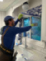 Husser technician thoroughly scrubbing interior kitchen windows at a Ballard rambler.