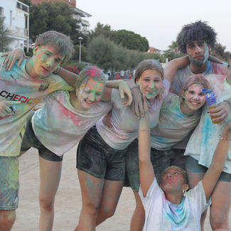 7 Jugendliche bei einem Holi-Festival voller bunter Kreide