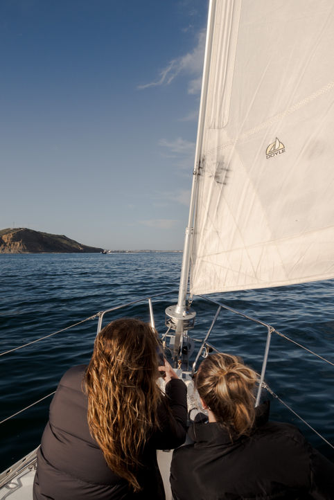 Two women on the bow of a sail boat