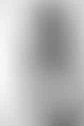 A woman holds a newborn baby to her chest and looks down at her