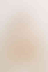 1 year old boy in beige overalls sits on small rattan chair