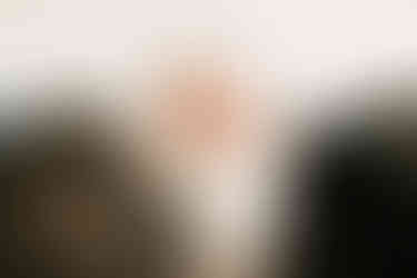 the back of a man's and woman's head as they look down at a newborn baby