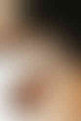 A woman looks down at a newborn baby in her arms