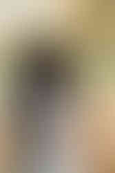 A woman cradles her pregnant stomach as a man stands behind her and rests his hands on her stomach