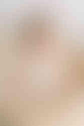 A one year old girl sits in a moses basket