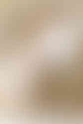 A man sits on a couch next to a woman who is holding a newborn baby