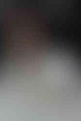 hair care products and a hair extension sit on a counter as a woman stands behind the counter and smiles