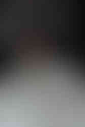 hair care products and a hair extension sit on a counter as a woman stands behind it and smiles