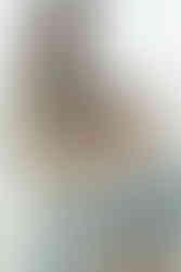 A pregnant woman stands beside a toddler who stands on a stool and rests a hand on her pregnant stomach