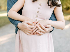 A woman's torso as a man stands behind her and wraps his hands around her
