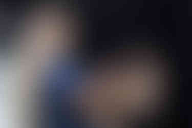 A hair dresser puts hair extensions into a client's hair