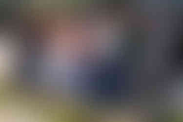 A group of 7 people lean against a concrete bench