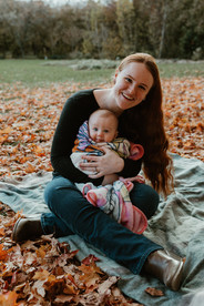 A woman cuddles a baby wrapped in a blanket