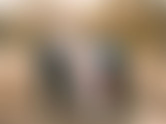 A couple stand in a forest with a dog, two girls, and an older couple