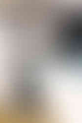 A pair of arms in a lab coat and gloves cleans a machine