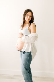 pregnant woman cradles her belly and looks down and away from her stomach