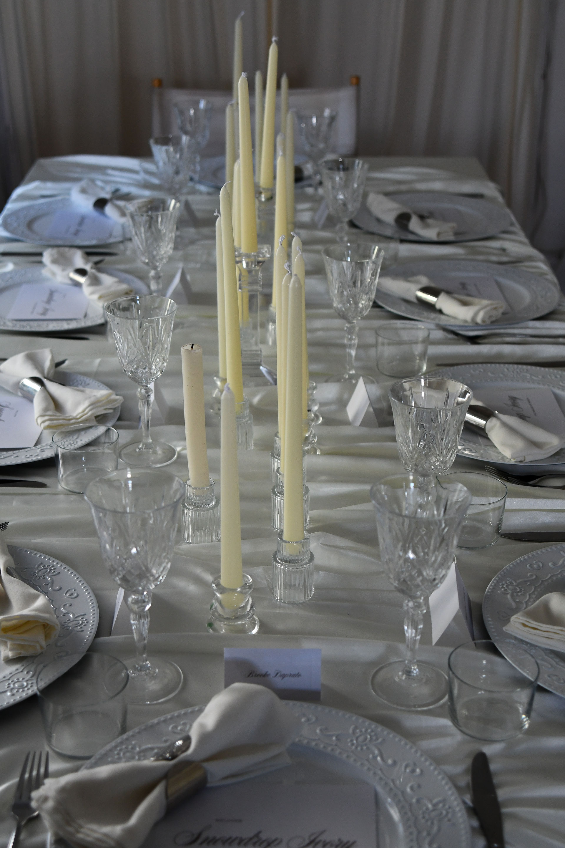Ivory white winter tablescape with candlelight and minimal styling, designed for luxury weddings and private events.