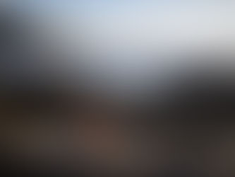 Frau schaut auf den Ozean und reflektiert über Wohlbefinden, Raumgestaltung und das Gefühl von Zuhause.