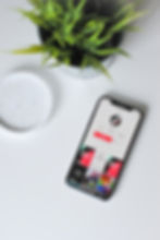 Smartphone posé sur un bureau avec une plante, symbolisant l’importance du marketing digital et des stratégies sur TikTok..