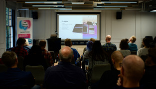 Audience members watching a presentation on the big screen