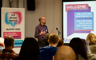 Ben Ackland giving his keynote on the presentation screen infront of audience
