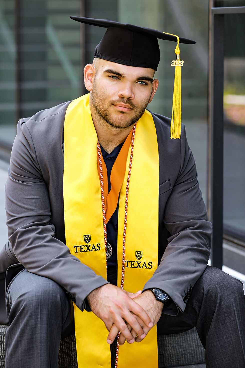 College graduation portrait of a man wearing a texas graduation cap and gown