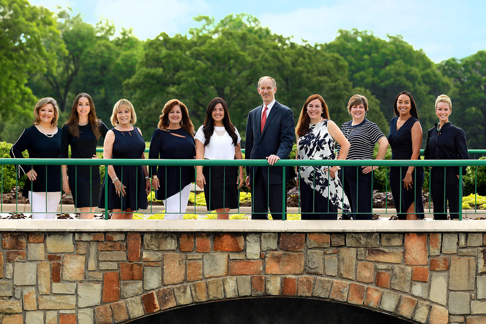a group of people posing for a picture on a bridge