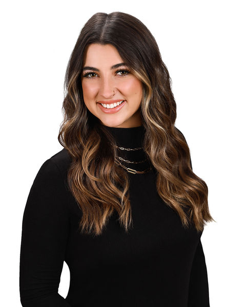 Marketing photo of woman wearing a black turtleneck smiles for the camera