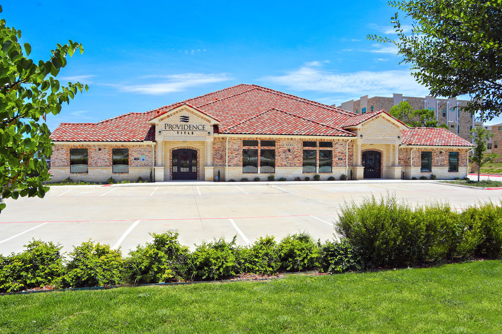photo of a large brick building with a sign that says providence suites
