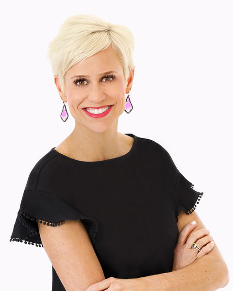 Headshot of Woman wearing a black top and pink earrings smiles for the camera