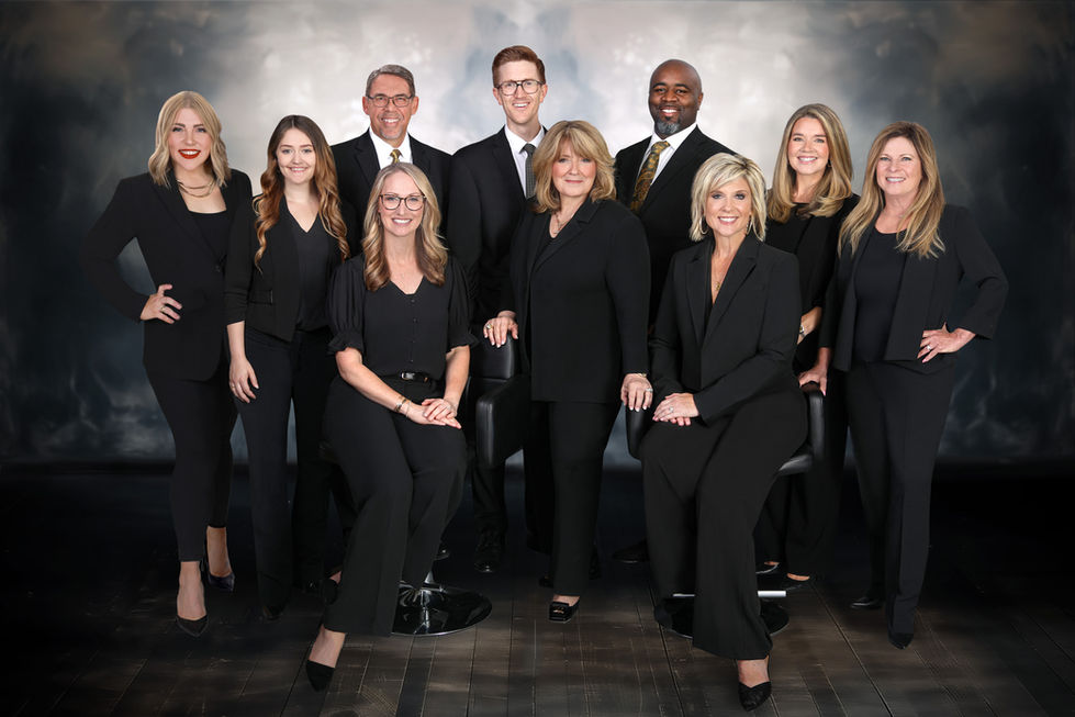 Portrait of a group of people in black suits pose for a picture