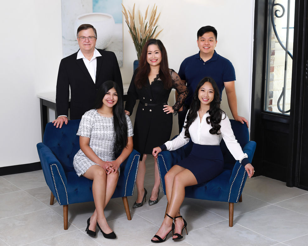 Portrait of a group of people posing for a picture with one woman sitting on a blue couch