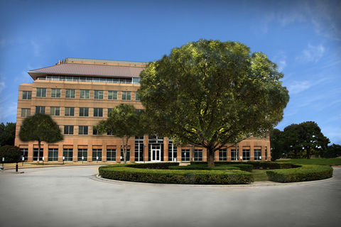 exterior photo of a large building with a tree in front of it