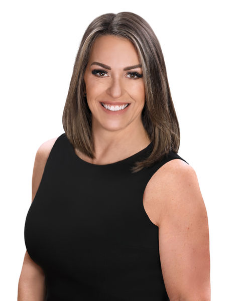 professional headshot of a woman in a black sleeveless dress smiles for the camera