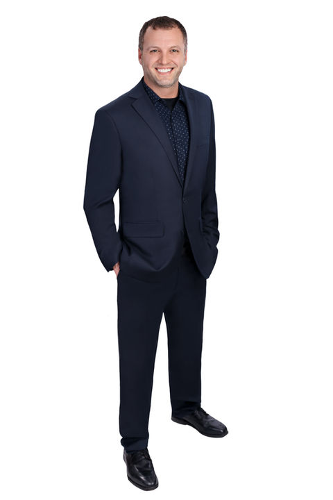 marketing photo of a man in a suit with his hands in his pockets