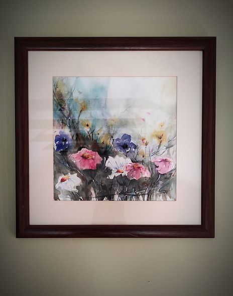 a framed painting of flowers hanging on a wall